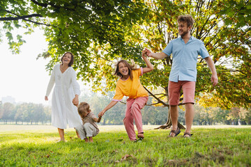 Happy family spending leisure time playing together at park