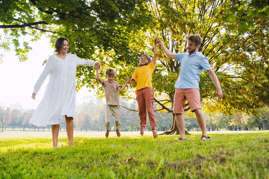 Father and mother lifting children at park