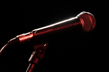 Professional microphone on a stand on a black background.