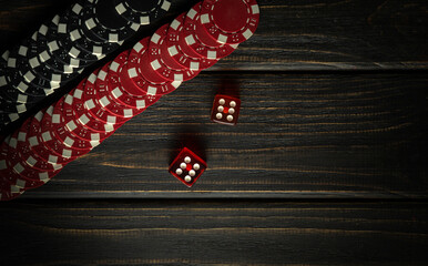 Craps or dice game on a dark vintage wooden table in a club. Red and black chips from a lucky win. Free dark space for advertising. Luck in gambling - obrazy, fototapety, plakaty