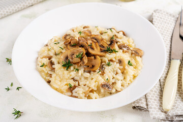 Dish with delicious risotto with mushrooms in plate. Rice porridge with fungus and tmyne. Hot dish, italian cuisine.