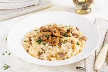 Dish with delicious risotto with mushrooms in plate. Rice porridge with fungus and tmyne. Hot dish, italian cuisine.