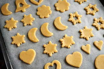 Shapes made of pastry dough on a baking sheet - preparation of Linzer Christmas cookies