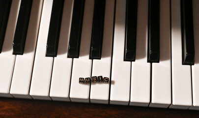 Naklejka premium Piano keys close-up. the word music. concept