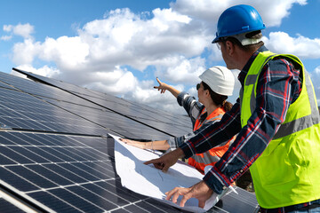 Young engineer inspect installation of solar panels installed check  with blueprint on the field,...