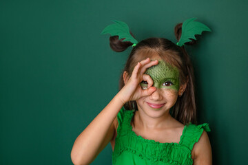 A beautiful girl dressed up as a dragon makes a gesture with her fingers ok. The symbol of the 2024...