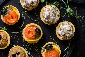 Dough tartlets with pate, mushrooms and salmon