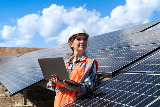 Young engineer inspect installation of solar panels installed check  with blueprint on the field, with recording inspection data on pc.