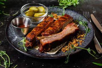 Grilled sausage on a dark plate with sauce