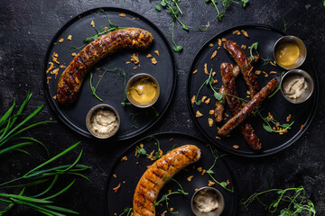 Grilled sausage on a dark plate with sauce