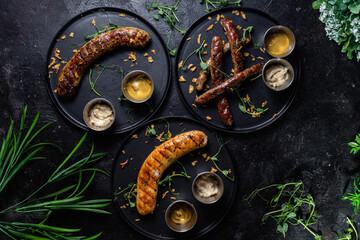 Grilled sausage on a dark plate with sauce