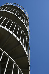 Spiral metal staircase for pedestrian traffic to the bridge against blue sky