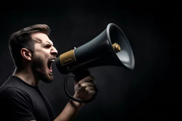 Fotobehang Young man on black background shouting through a megaphone to announce something in lateral position © Werckmeister
