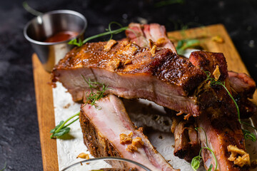 Grilled pork ribs on a wooden board with sauce