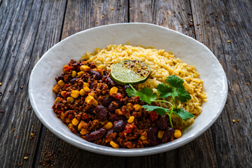Chili con carne with rice on wooden table