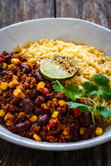 Chili con carne with rice on wooden table