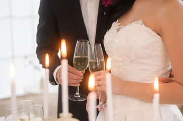 Bride and groom holding glasses of champagne at the wedding ceremony