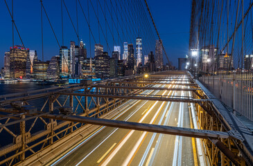Fototapeta na wymiar Traffic lights on Brooklyn bridge at night with Manhattan skyscrapers on the background