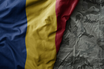 waving flag of romania on the old khaki texture background. military concept.