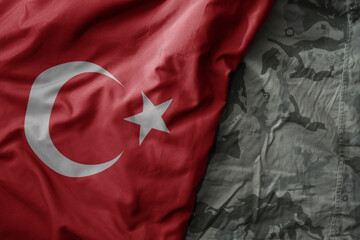 waving flag of turkey on the old khaki texture background. military concept.