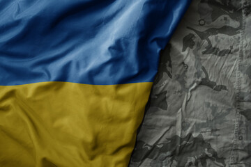 waving flag of ukraine on the old khaki texture background. military concept.