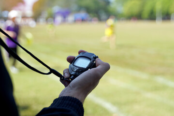 The coach timed the finish line with a stopwatch to determine the winner of the school sports day...