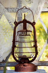 An old rusty kerosene lamp on an old wooden window overlooking the garden.