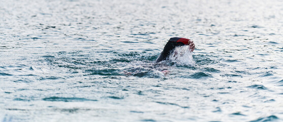 A professional triathlete trains with unwavering dedication for an upcoming competition at a lake,...