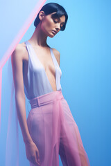 Female model posing in studio on blue background,fashion editorial,pastel colors,minimal concept.