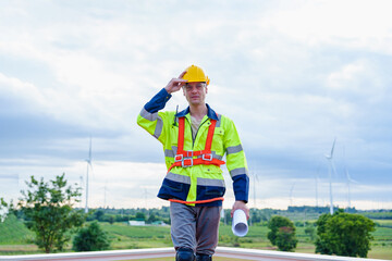 Portrait of Technician engineer worker builders looking for wind turbine blueprint drawings for wind turbine construction at windmill field farm. Alternative renewable energy