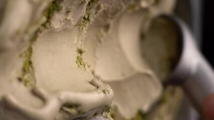Pistachio ice cream taking with scoop from package. Making ball of ice cream. Flat lay. Top view.