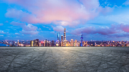 Asphalt road and city skyline with skyscraper at night in Shanghai, China. High Angle view.
