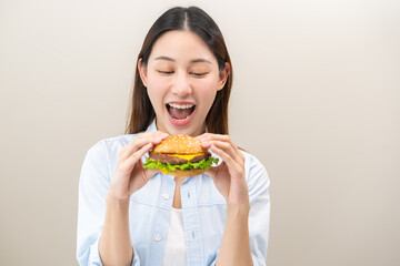 Fast Food concept, happy delicious asian young woman eating tasty burger or hamburger with...