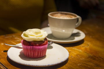 Close up view of a person eating a cake and a coffee