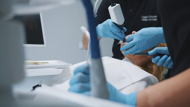 Competent dental doctor doing advanced jaw diagnostics of female patient using ultrasound cleaning imaging computer technique in private clinic. Progressive dentistry.