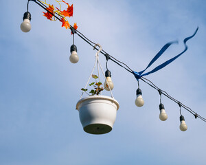 Shiny colorful ribbons and lamps waving with wind. Blue sky. Decor outdoor