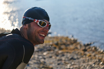Authentic triathlon athlete getting ready for swimming training on lake