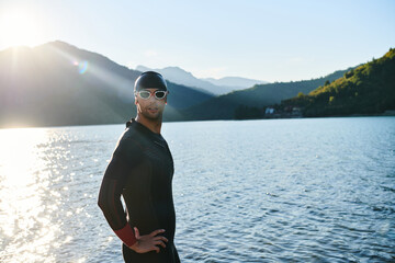 Authentic triathlon athlete getting ready for swimming training on lake