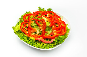 Raw patterned sliced red pepper, green salad leaves in a white bowl. Healthy vegetable background.