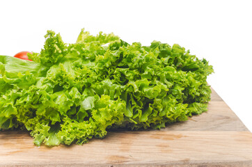 Green salad leaves on wooden cutting board. Side view. Preparing a salad for snack.