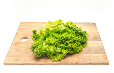 Green salad leaves on wooden cutting board.Top view. Preparing a salad for snack.