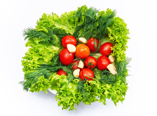 Mix of fresh vegetables - dill, garlic, tomatoes and green salad leaves. White background, isolated.