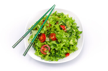 White plate of salad with vegetables isolated on white background. Wooden chopsticks for food.