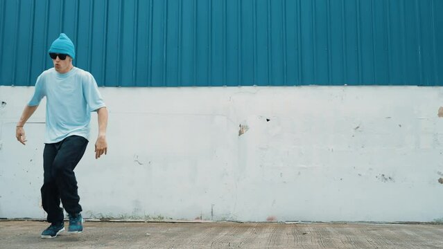 Full body of youthful hipster moving in lively groove at street. Caucasian break dance choreographer dancing in hip hop style. Energetic dancer perform b-boy dance. Outdoor sport 2024. hiphop.