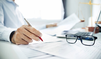 Close-up shot, businessman or lawyer holding pen reviewing documents and contact customer via...