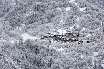 snow covered old village and trees in the mountains of Val d'Anniviers in Switzerland - 688093220