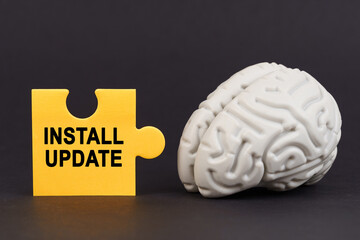 On a black surface there is a brain and a yellow puzzle with the inscription - Install Update
