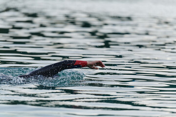 A professional triathlete trains with unwavering dedication for an upcoming competition at a lake,...