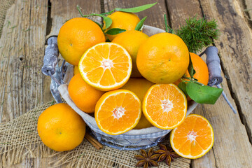 fresh tangerines in a basket on wooden background