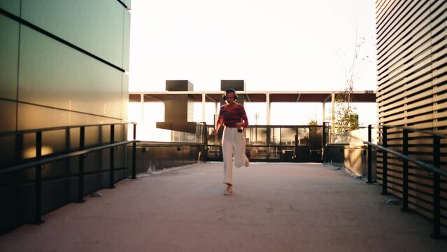 Determined and confident female in headphones run fas in urban setting while feels carefree. Young Caucasian woman feeling motivate while listens to music in earphones, thinking about life.Slow motion